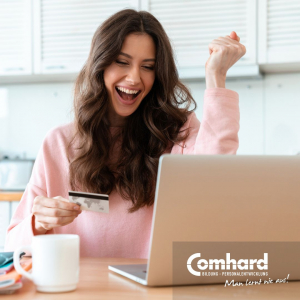 Eine Frau sitzt vor einem Laptop und freut sich
