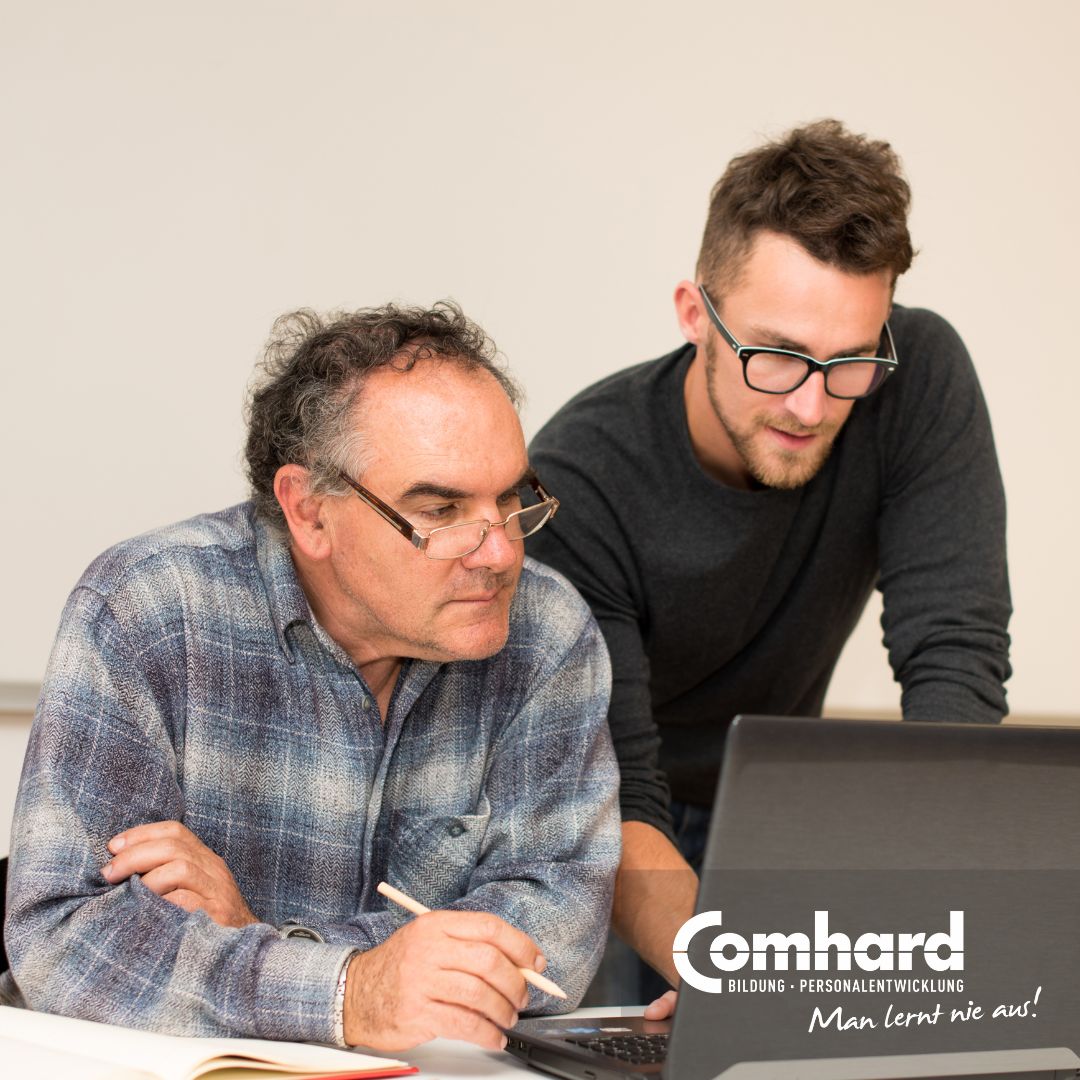 Zwei Männer schauen konzentriert auf einen Laptop