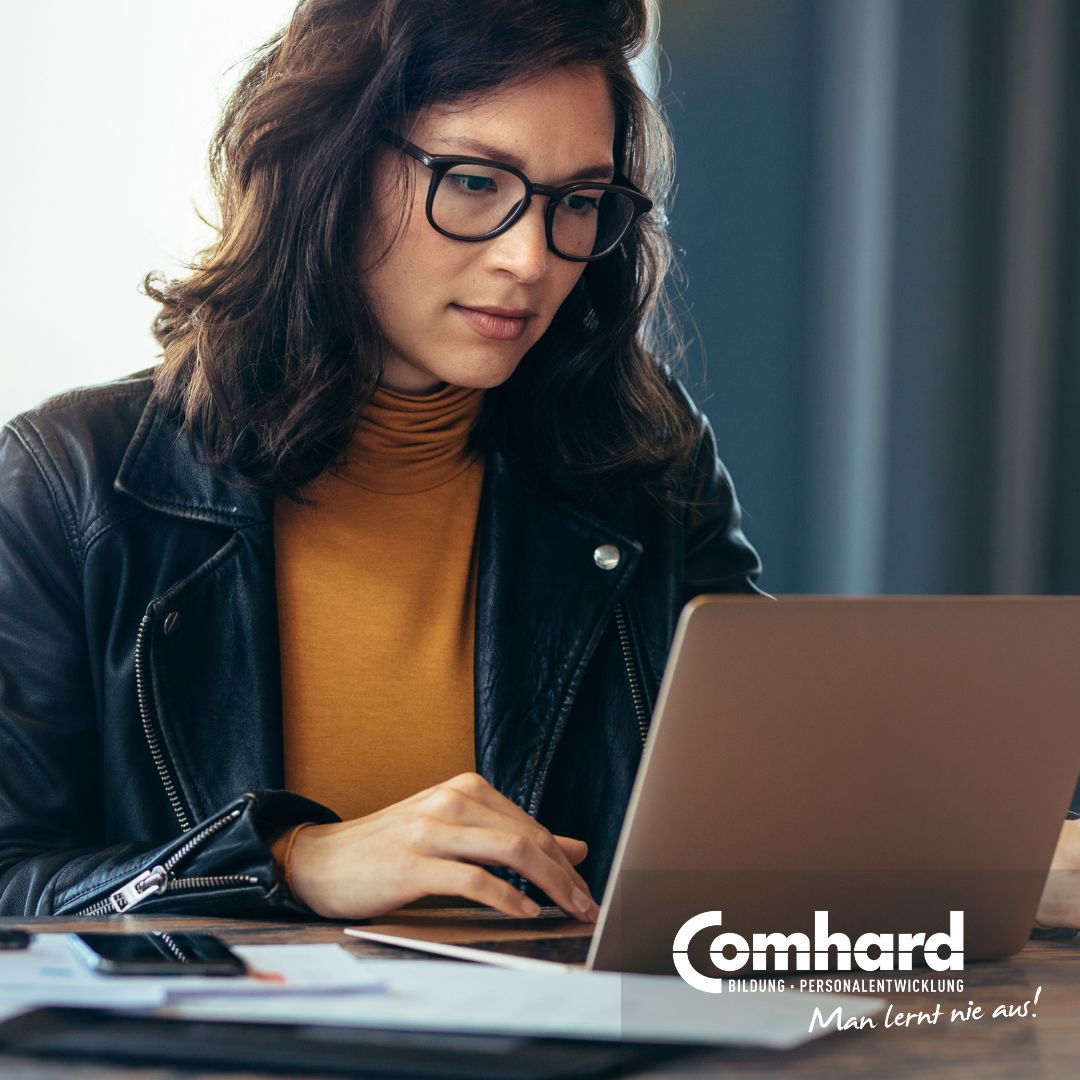 Eine Frau sitzt konzentriert vor einem Laptop