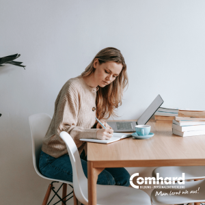Junge Frau lernt zu Hause am Tisch mit Laptop, Notizbuch und Büchern für eine Online-Weiterbildung in Teilzeit.