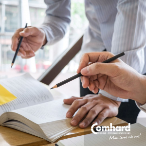 Mehrere Hände mit Stiften in der Hand über einem Buch